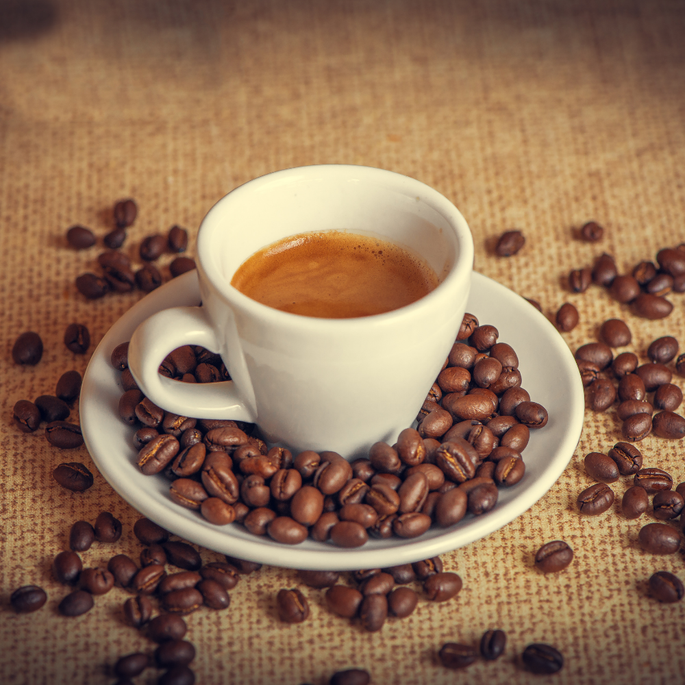 Ein Espresso mit einer tollen Crema und ein paar Kaffeebohnen auf einem Kaffeesack. 