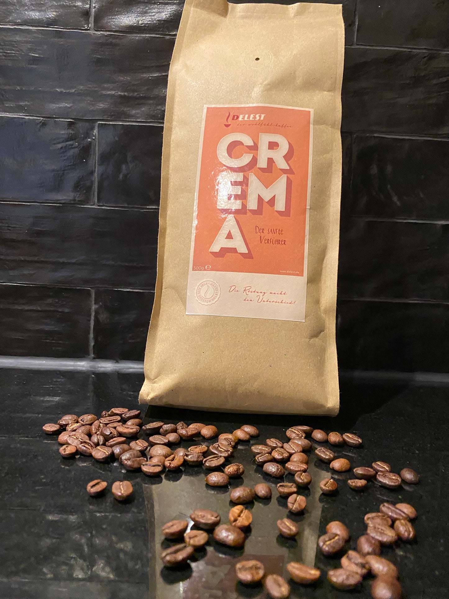 DELEST Crema Kaffeebeutel mit ganzen Kaffeebohnen auf dunklem Schieferhintergrund