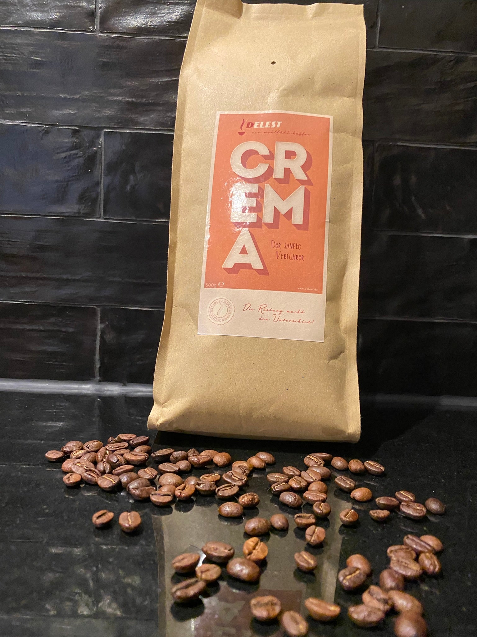 DELEST Crema Kaffeebeutel mit ganzen Kaffeebohnen auf dunklem Schieferhintergrund
