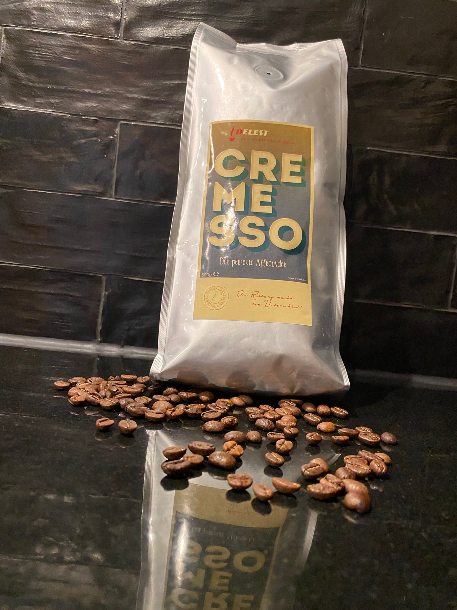 DELEST Cremesso Kaffeepackung umgeben von gerösteten Kaffeebohnen – Nahaufnahme